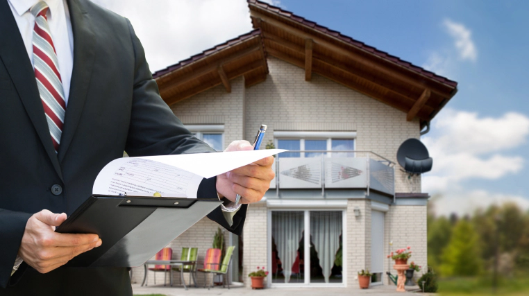 appraiser holding a document while standing in front of a house